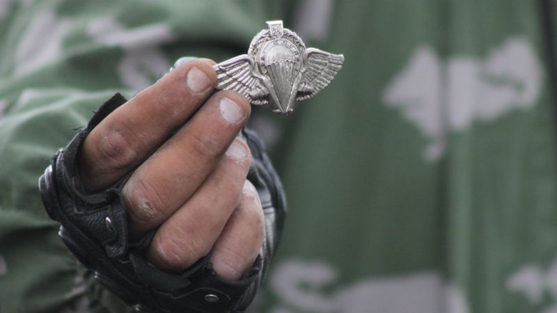 Бойовик "ЛНР" тримає знак українських десантників на місці падіння Іл-76