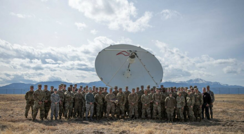 Члени 4-ї ескадрильї космічного контролю стоять перед блоком 10.2 системи контркомунікацій на базі космічних сил Петерсон, Колорадо. Авторство: ВПС США