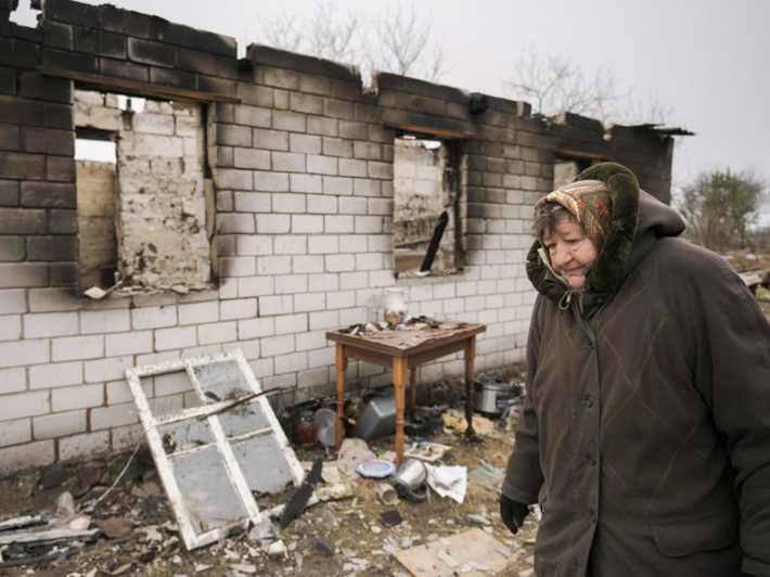 Жінка проходить повз зруйнований будинок в Андріївці, 5 квітня 2022 року, фото: AP Photo/Vadim Ghirda