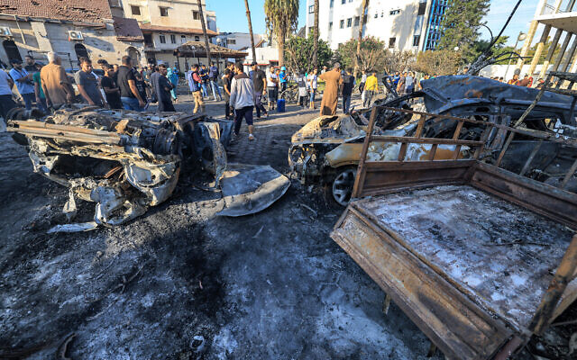 Люди шукають уламки біля території лікарні Ахлі Араб у центрі Гази 18 жовтня 2023 року після вибуху. (Махмуд Хамс/AFP)